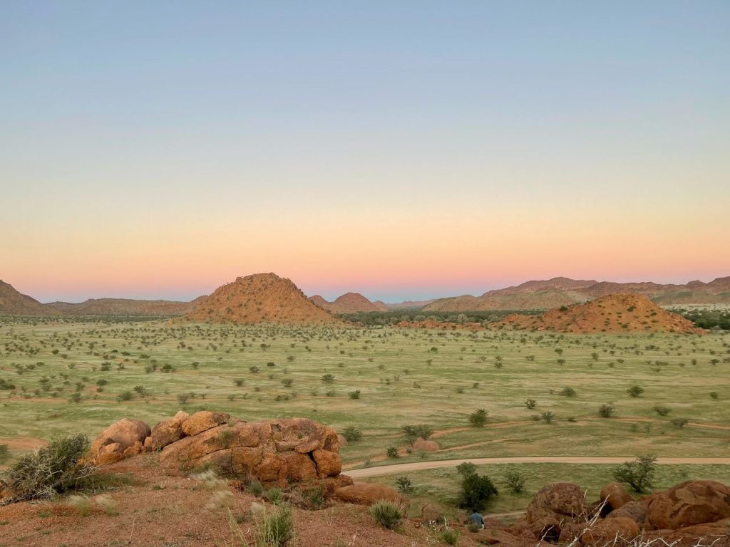 Sunset over a green season Namibian landscape with granite boulders and scattered bush