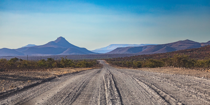 Gravel road stretching toward a pointed mountain peak in Damaraland, Namibia